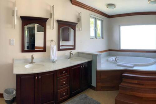 a bathroom with two sinks and a bath tub at Villa Xona in Castries