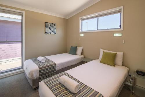 two beds in a room with two windows at Ingenia Holidays Hunter Valley in Cessnock