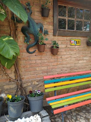 a colorful bench in front of a wall with plants at Capricho Asturiano in Santo Antônio do Leite