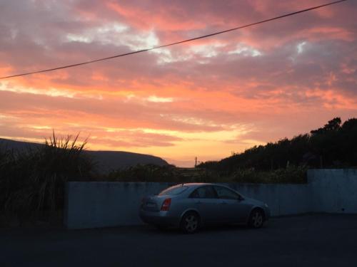 a car parked in a parking lot with a sunset at Creevagh (Room Only) in Keel
