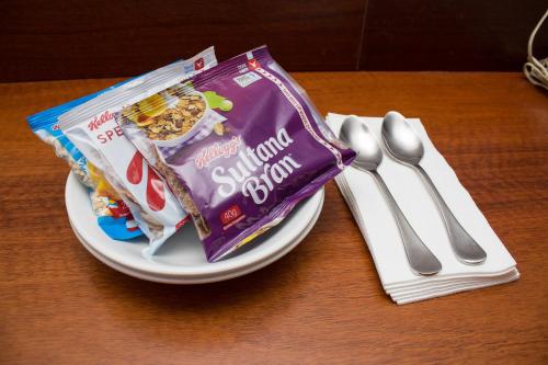 Highlander Hotel Bar Kitchen Rooftop في أديلايد: طبق عليه كيس من الحلوى بجانب طقم أدوات مائدة فضية