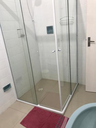 una doccia con porta in vetro in bagno di Mar azul Enseada a Guarujá