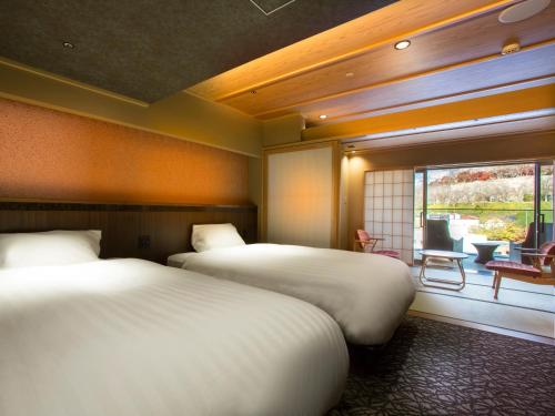 a hotel room with two beds and a window at The Shiroyama Terrace Tsuyama Villa in Tuyama