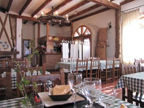 a restaurant with tables and chairs with wine glasses at Casa Rural de la Abuela in Montejo de Tiermes