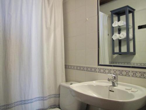 a bathroom with a white shower curtain and a sink at Casa Rural de la Abuela in Montejo de Tiermes