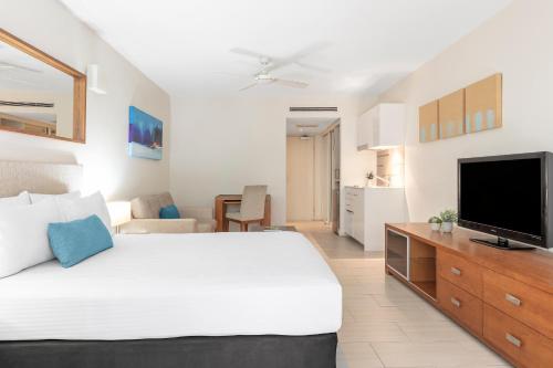 a bedroom with a large bed and a television at Drift Palm Cove in Palm Cove