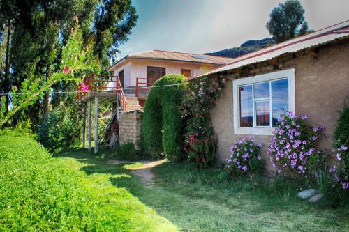 una casa con flores a un lado. en Inca lodge - Amantani en Ocosuyo