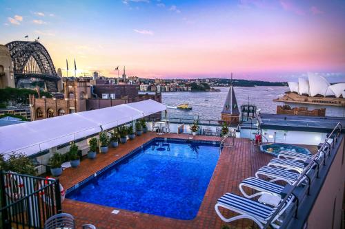 a swimming pool on the roof of a building with a view of the syd at Sydney Harbour Hotel in Sydney