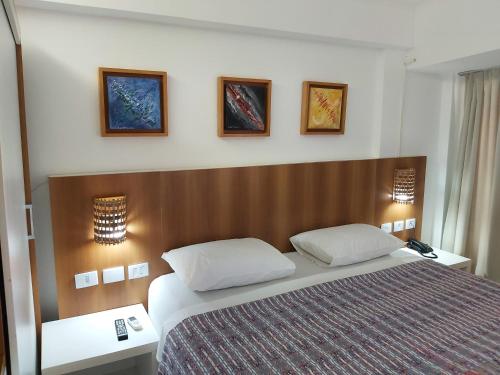 a bedroom with a large bed with two pillows at Pipa's Bay Flats in Pipa