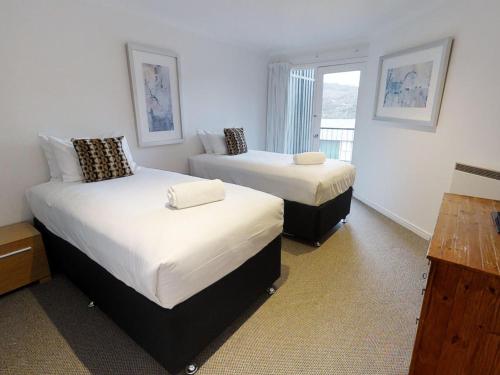 um quarto com 2 camas e uma janela em Lodge Apartment 20 The Stables Perisher em Perisher Valley