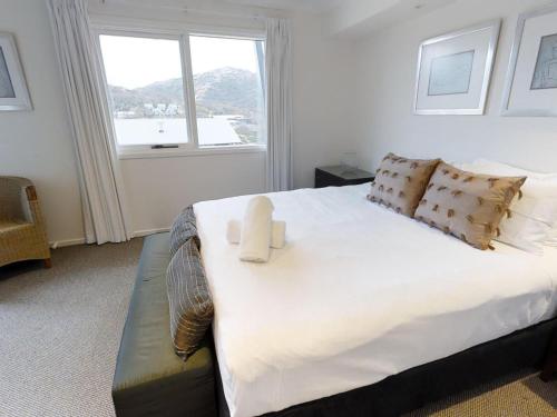 a bedroom with a large white bed with a window at Lodge Apartment 20 The Stables Perisher in Perisher Valley