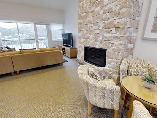 a living room with a couch and a fireplace at Lodge Apartment 20 The Stables Perisher in Perisher Valley