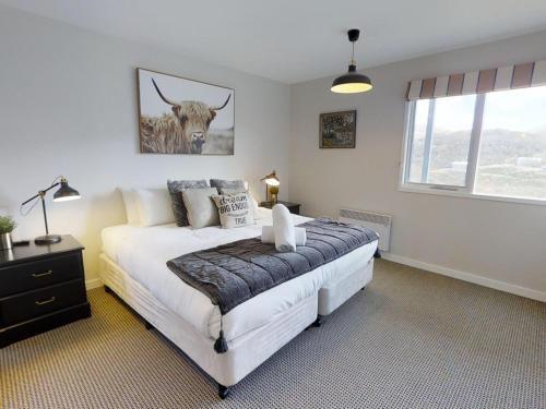 a bedroom with a bed with a bull picture on the wall at Lodge Chalet 16 - The Stables Perisher in Perisher Valley