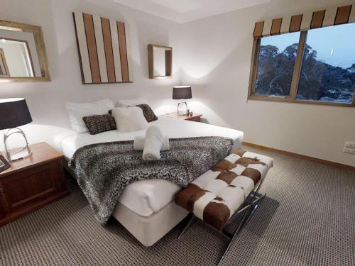 瑞雪谷的住宿－Lodge Chalet 26 - The Stables Perisher，一间卧室设有一张大床和一个窗户。
