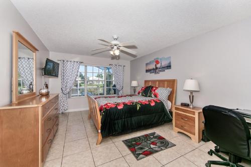 a bedroom with a bed and a dresser and a window at Mickey's Lake Villa 2 in Orlando