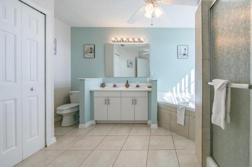 a bathroom with a sink and a toilet and a mirror at Mickey's Lake Villa 2 in Orlando