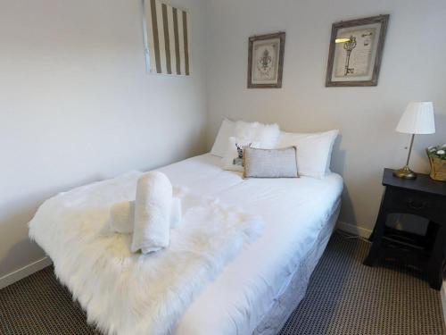 a bedroom with a white bed with towels on it at Lodge Chalet 16 - The Stables Perisher in Perisher Valley