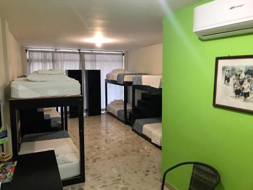 a room with a green wall and several bunk beds at Hostal Casa Huasteca in Ciudad Valles