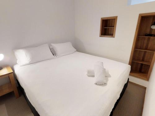 a bedroom with a white bed with towels on it at Apartment 3 The Stables Perisher in Perisher Valley