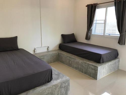 1 dormitorio con 2 camas y ventana en Live In Leaf Koh Tao, en Ko Tao