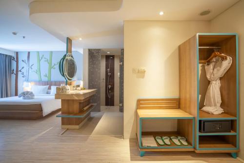 a hotel room with a bed and a bathroom at Grand Livio Kuta Hotel in Legian