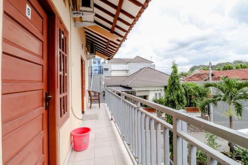 a balcony of a house with a red door at Griya Barokah in Kalasan
