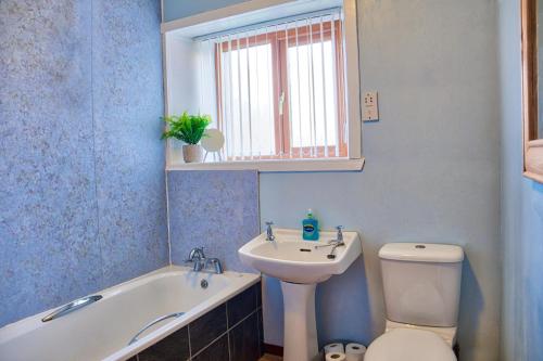 y baño con lavabo, bañera y aseo. en North Coast Property - North Coast House en Thurso