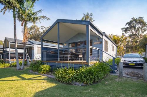 a blue house with a car parked in front of it at Ingenia Holidays Lake Macquarie in Mannering Park