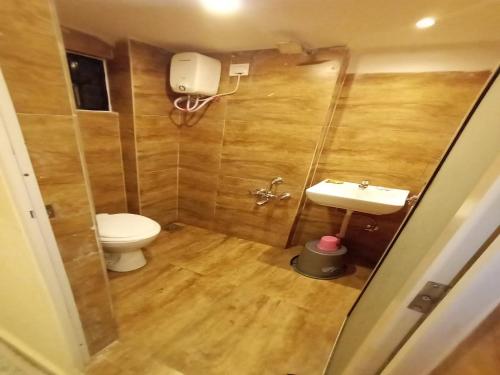 a bathroom with a toilet and a sink at Radhe-The Hotel in Vadodara