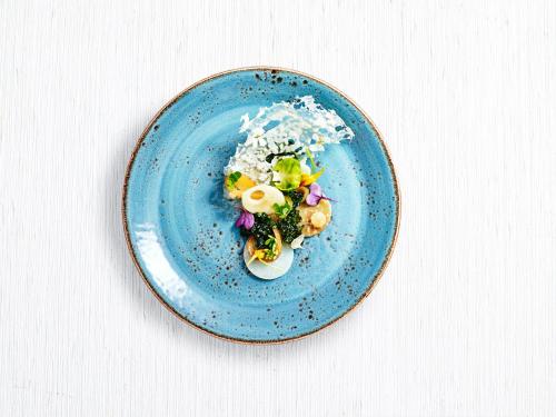 a blue plate with an egg and vegetables on it at Orpheus Island Lodge in Orpheus Island