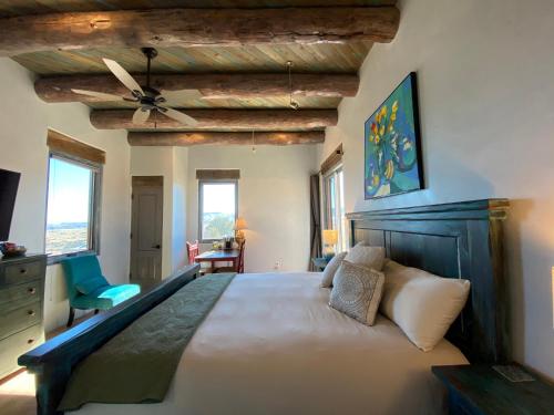 Un dormitorio con una cama grande con ventilador de techo. en The Grand Hacienda Inn with Breakfast, en Abiquiu