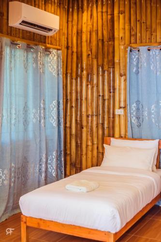 a bed sitting in a room with bamboo at Ceazar's Place in Dauin