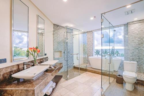 ein Badezimmer mit einer Badewanne, einem WC und einem Waschbecken in der Unterkunft Boracay Ocean Club Beach Resort in Boracay