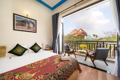 a bedroom with a bed and a large window at Ri's House Hoi An Homestay in Hoi An