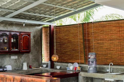 eine Küche mit einem Waschbecken und einem großen Fenster in der Unterkunft Colombo Beach Hostel in Mount Lavinia