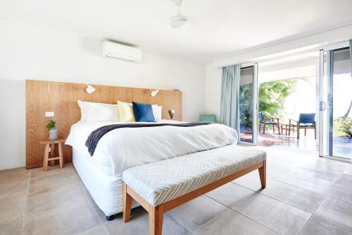 a bedroom with a large bed and a balcony at Orpheus Island Lodge in Orpheus Island