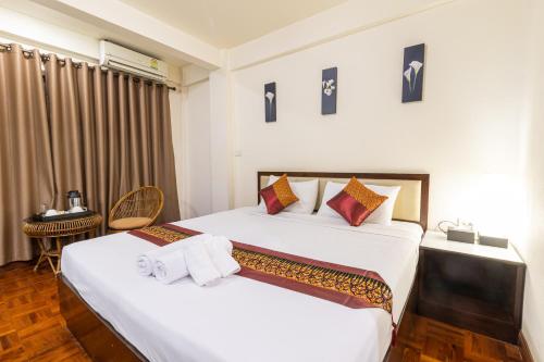 um quarto de hotel com duas camas e uma mesa em The Palm Garden Hotel em Chiang Rai