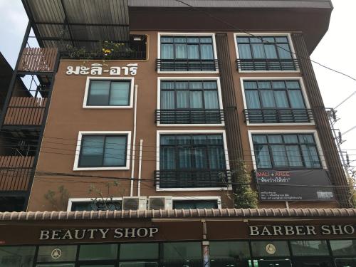 a tall building with a barber shop in front of it at Baanmali Ari in Pathum Thani