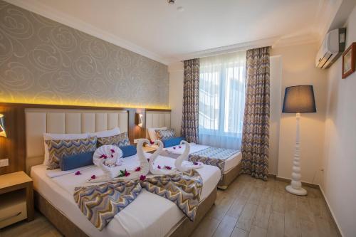 two beds in a hotel room with swans on them at Club Big Blue Suit Hotel - All Inclusive Plus in Alanya