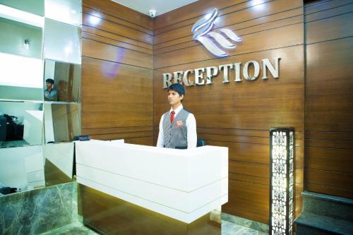 a man standing at a reception desk in a building at La Hotel Metro near BKC in Mumbai