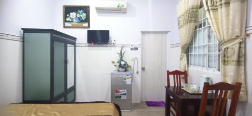 a room with a refrigerator and a table and a door at Duong Hieu Guesthouse in Phu Quoc