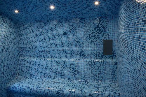 ミネラルニ・バニにあるХотел "Божур"の青いタイル張りのバスルーム(バスタブ付)が備わります。