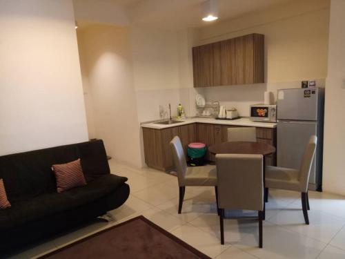 uma sala de estar com um sofá e uma cozinha em Studio Homestay SGarden Resort Residences em Kuantan