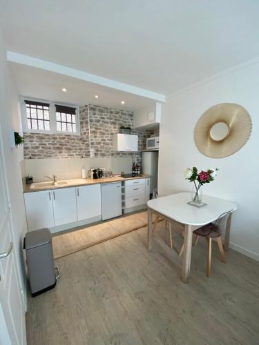 une cuisine avec une table blanche et un comptoir blanc dans l'établissement Studio Clémenceau, à Beaune