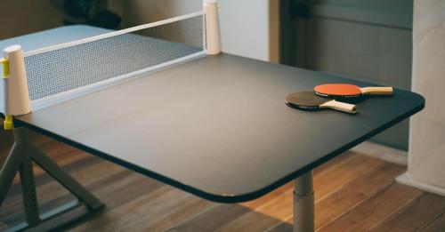 a ping pong table with a pair oficans on it at Goonnight Hostel in Kaohsiung