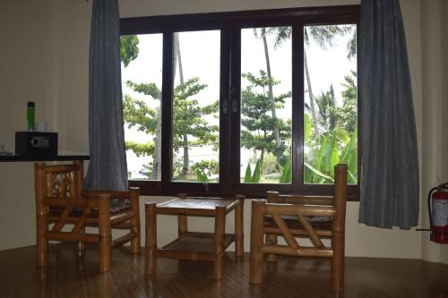 a dining room with a table and chairs and a large window at Jonas and Twins Resort in General Luna