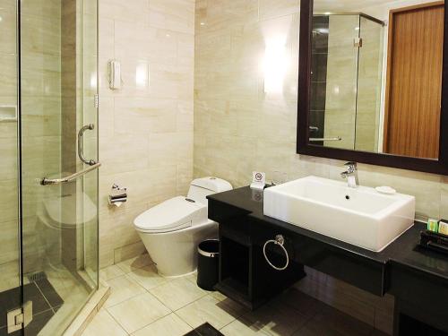 a bathroom with a sink and a toilet and a shower at Java Palace Hotel in Cikarang