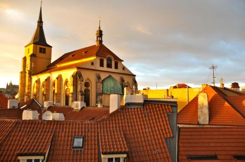 eine Kirche mit roten Dächern im Vordergrund in der Unterkunft Dolce Vita Suites Boutique in Prag