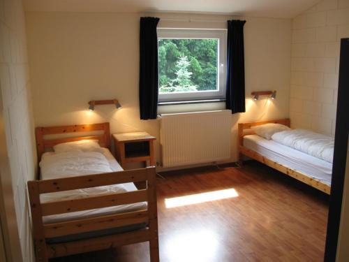 een kamer met 2 bedden en een raam bij Oberes Ourtal Lodge in Bullange