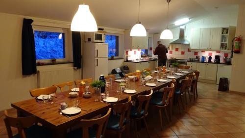 a long wooden table in a kitchen with chairs and a man at Oberes Ourtal Lodge in Bullange